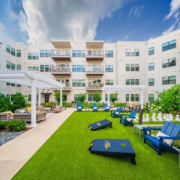 A white building with blue chairs and tables in front.
