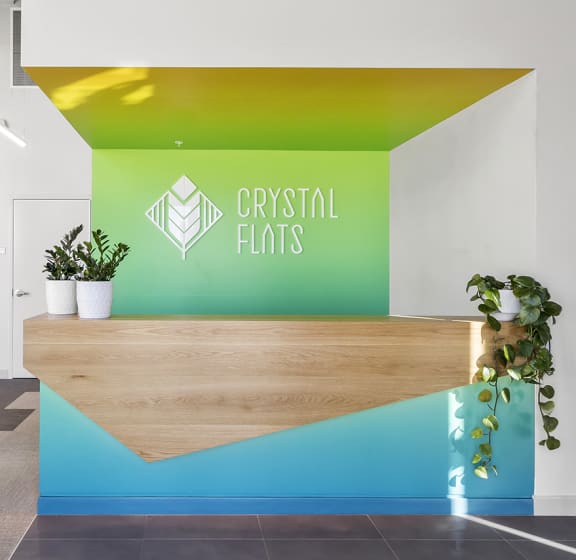 a reception area with a wooden reception desk and a green and yellow wall behind it