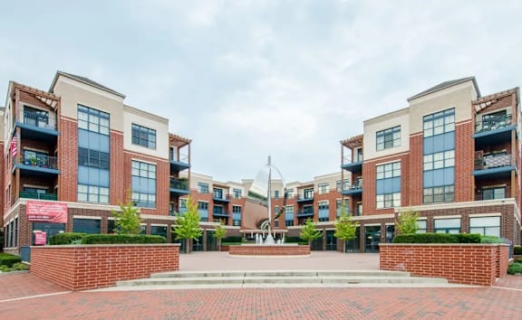 A large brick building with a courtyard in front.