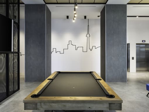a pool table sits in the middle of a room with a cityscape painted on the wall