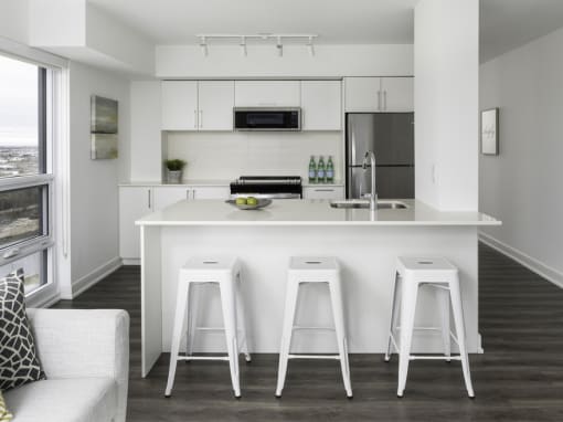 a kitchen with a counter top and three stools