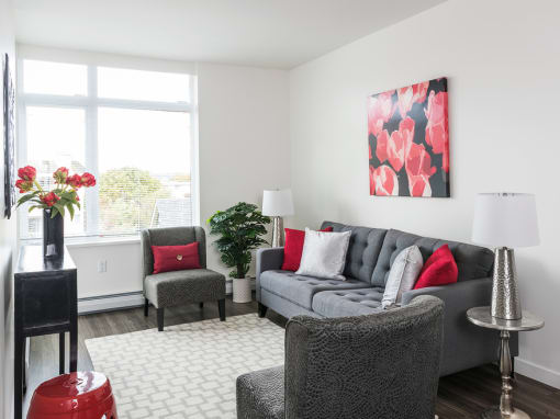 a living room with a gray couch and red pillows