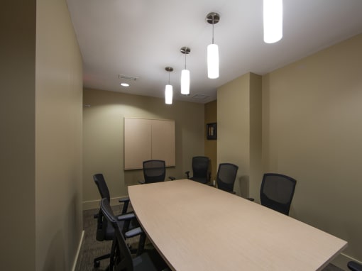 a meeting room with a long table and black chairs