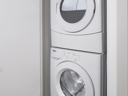a front loading washer and dryer stacked on top of each other