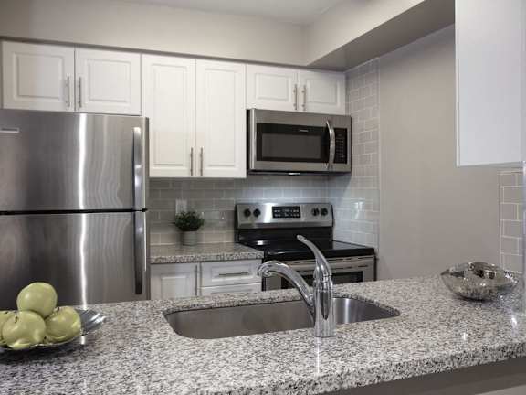 a kitchen with granite counter tops and stainless steel appliances