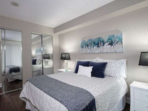 a bedroom with a large bed and a mirrored closet