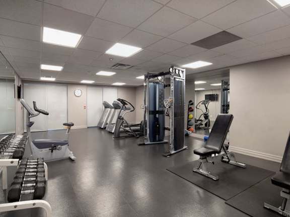 a gym with cardio equipment and weights in a building