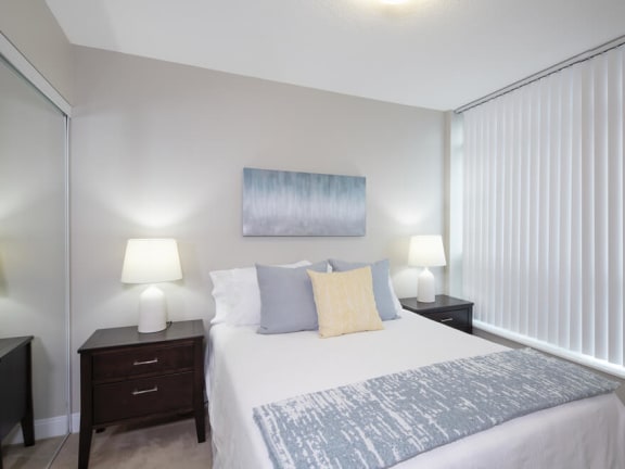 a bedroom with a large bed and two night stands with lamps