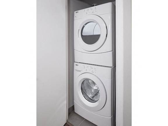 a front loading washer and dryer in a white closet