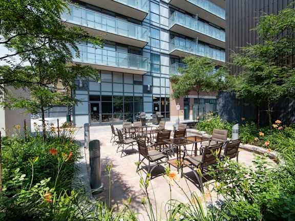a courtyard with tables and chairs in front of a building