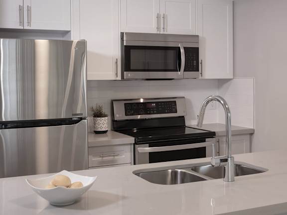 a kitchen with a sink a stove and a refrigerator