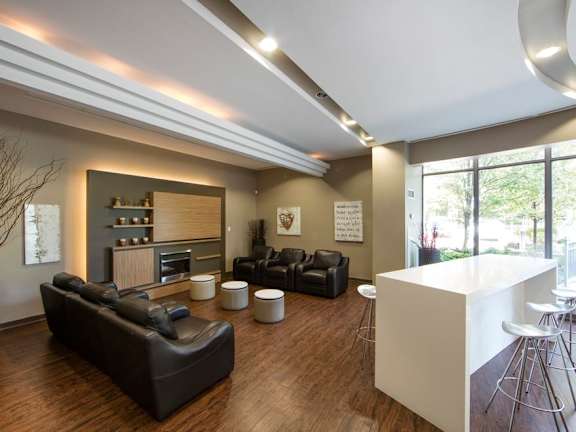 a living room with leather couches and stools