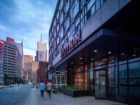 people walking down a sidewalk in front of a building