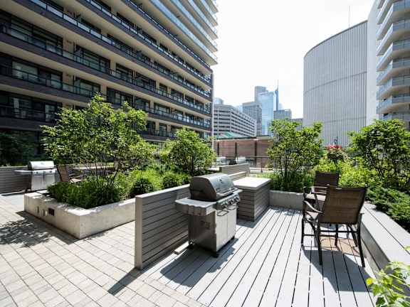a bbq grill on a roof terrace with a view of the city in the