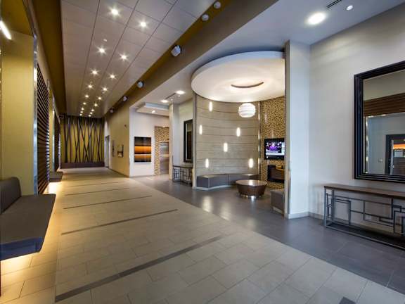 a lobby with a tv and a couch in front of a fire place