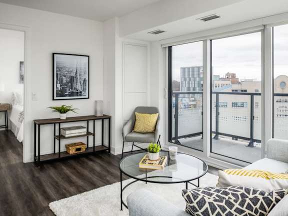 a living area with a couch coffee table and large windows