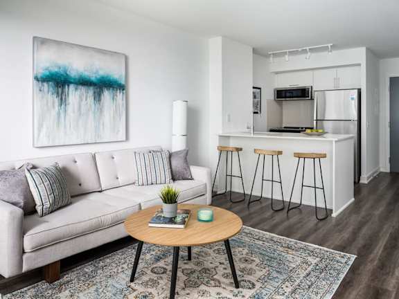 a living room with a couch a table and a kitchen in the background