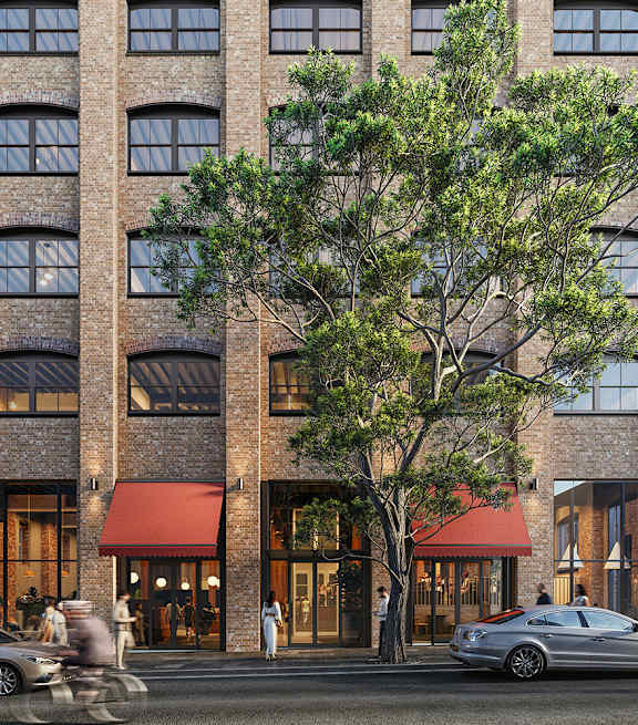 A tall building with a red awning and a tree in front.
