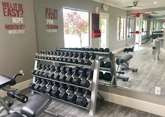 A gym with a row of dumbbells and a mirror at Sharlands Terrace Apartments, Apartments, Reno, NV