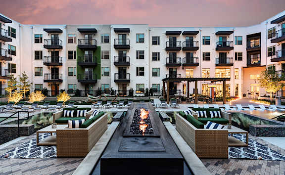A modern apartment complex with a central courtyard and seating area.