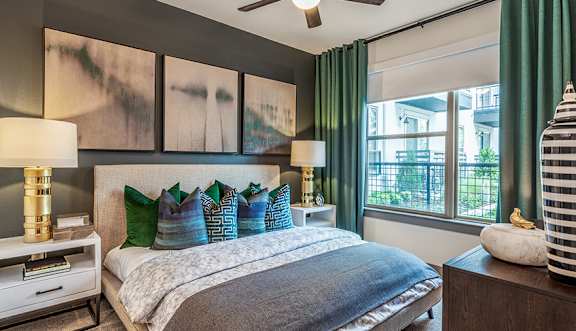 A bedroom with a bed, nightstand, and a ceiling fan.