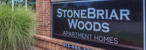 a kitchen with granite countertops and white cabinets at Stonebriar Woods Apartments, Overland Park, KS