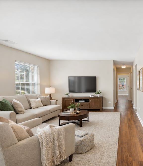 A living room with a couch, chair, and television.
