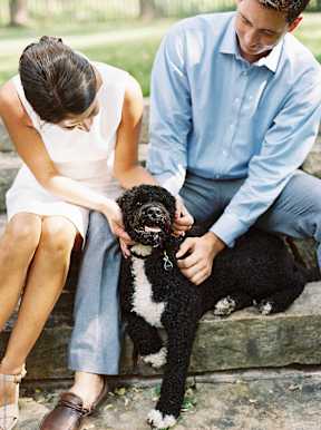 a man and woman sitting with a dog