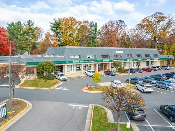 A parking lot in front of a building with a green roof.