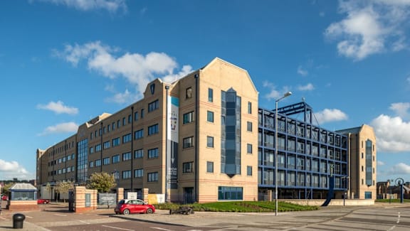 a large building with a red car parked in front of it at The Keel Apartments, Liverpool, L3 4GE
