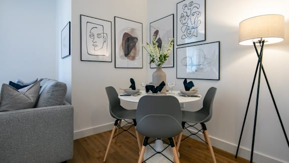 a dining room with a table and chairs and a lamp at The Keel Apartments, Liverpool, L3 4GE