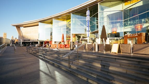 a large glass building with stairs in front of it at The Keel Apartments, Liverpool, L3 4GE