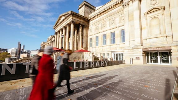 people walking in front of the library of the city at The Keel Apartments, Liverpool, L3 4GE