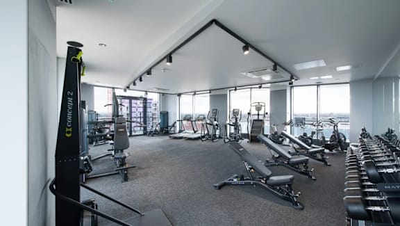 a gym with cardio equipment and windows in a building at Vox Apartments, Manchester, M15 4YD