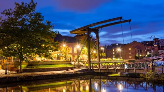 a city at night with a swing bridge over a river at Vox Apartments, Manchester, M15 4YD