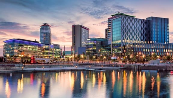 the city with its tall buildings at sunset at Vox Apartments, Manchester