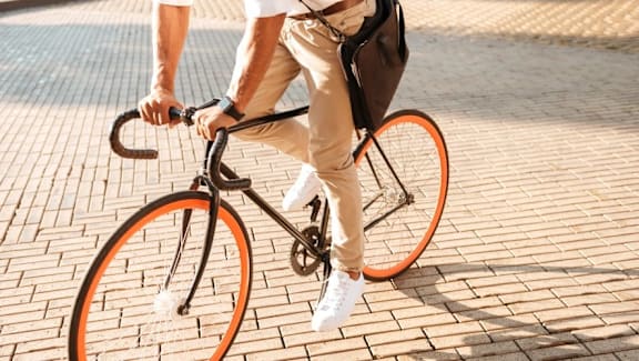 a man riding a bike on a brick sidewalk at Vox Apartments, Manchester, M15 4YD