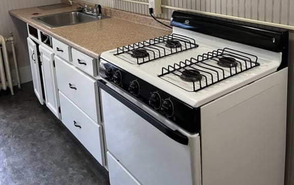 a kitchen with white cabinets and a white stove top oven