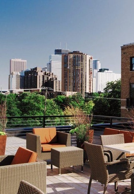 a roof deck with furniture and a city in the background