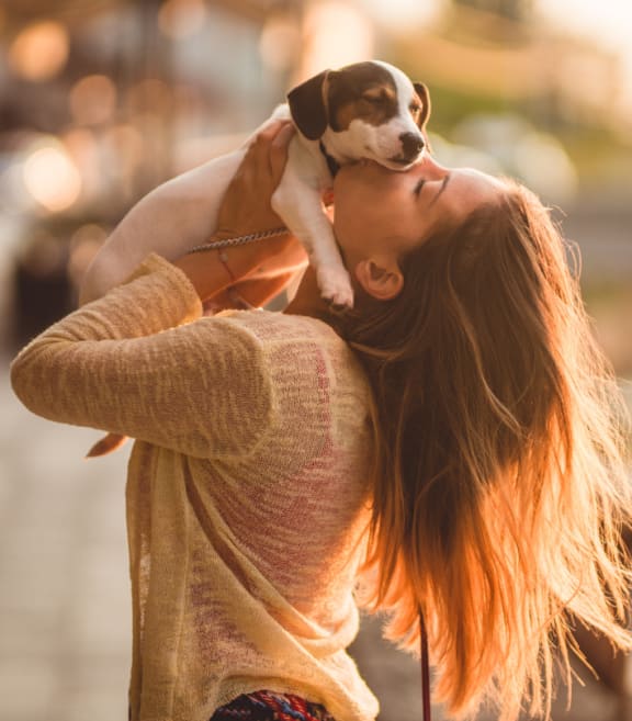 a woman holding a dog on her shoulders