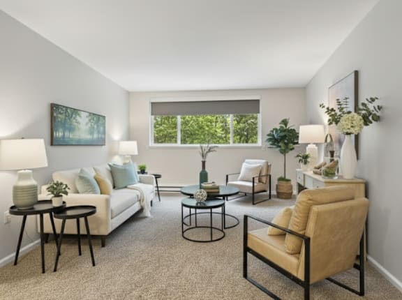 A living room with a white couch, a black coffee table, and a painting on the wall.