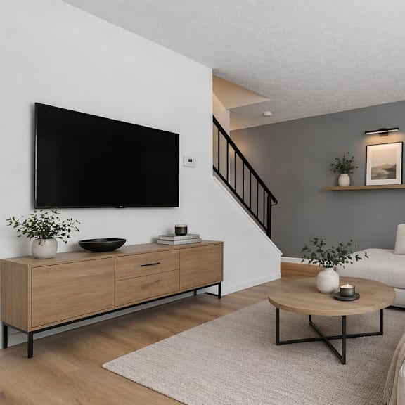 A living room with a white couch, a coffee table, and a painting on the wall.