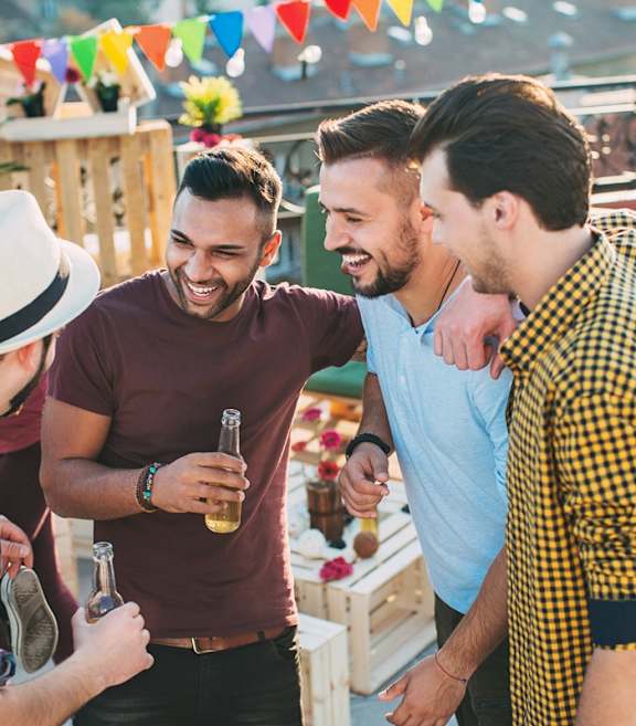 A group of friends are enjoying drinks together on a rooftop.