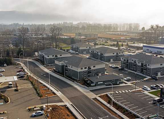 A view of a parking lot and buildings from an aerial perspective.