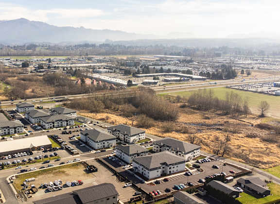 A large building complex with a parking lot in front of it.