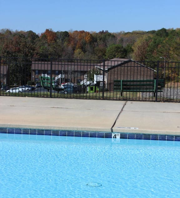 a swimming pool with chairs and a railing on the side of it