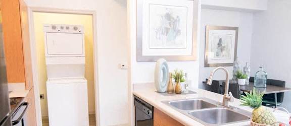 A kitchen with a sink, refrigerator, and oven.