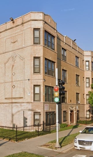 a building on the corner of a street with cars parked in front of it