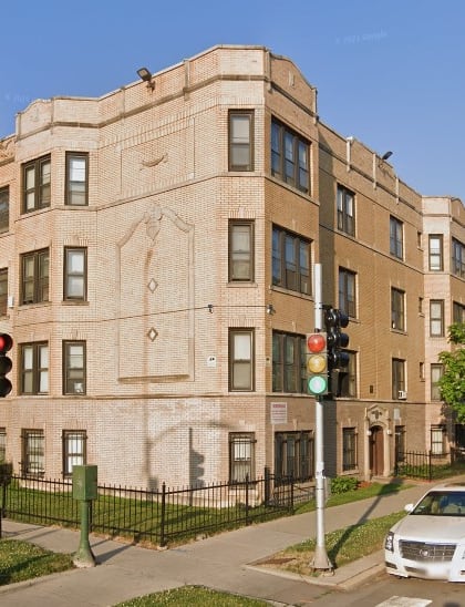 a building on the corner of a street with cars parked in front of it