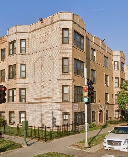 a building on the corner of a street with cars parked in front of it